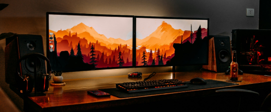 A desk with a computer and speakers on it.